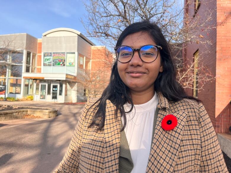 Sweta Daboo facing the camera with UPEI Student Union building behind her.