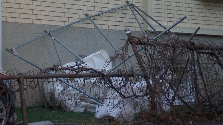 Jumble of steel poles up against side of house.