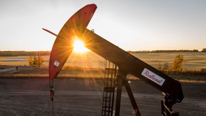 A pumpjack extracts oil as the sun sets. 