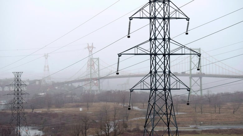 a power line in a field on a foggy day.