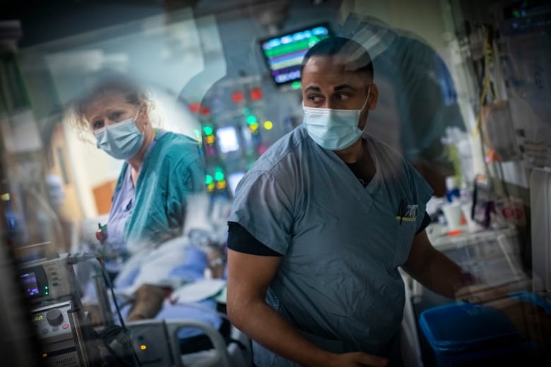 A nurse checks on a patient in the intensive care unit (ICU)