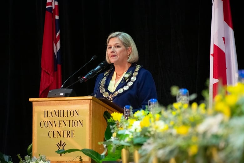 A woman stands at a podium.