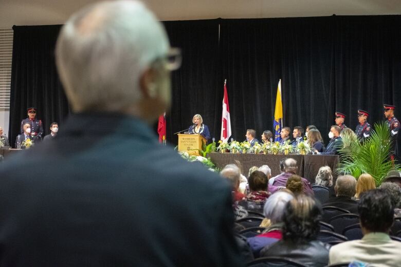 A crowd watches a speech.