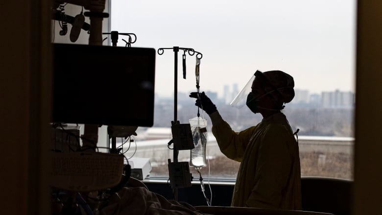 A nurse attends to a COVID-19 positive patient in the Humber River Hospital intensive care unit on Jan. 13, 2022.