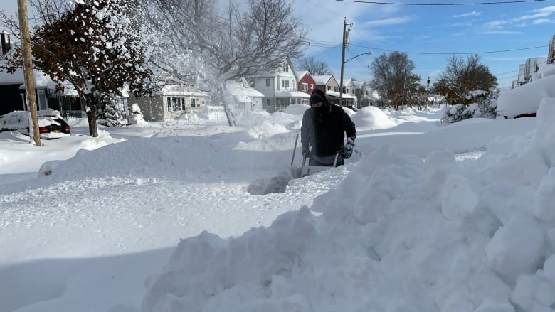 A man uses a snowblower