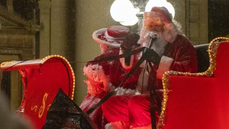 Santa is pictured in a sleigh float at a parade.