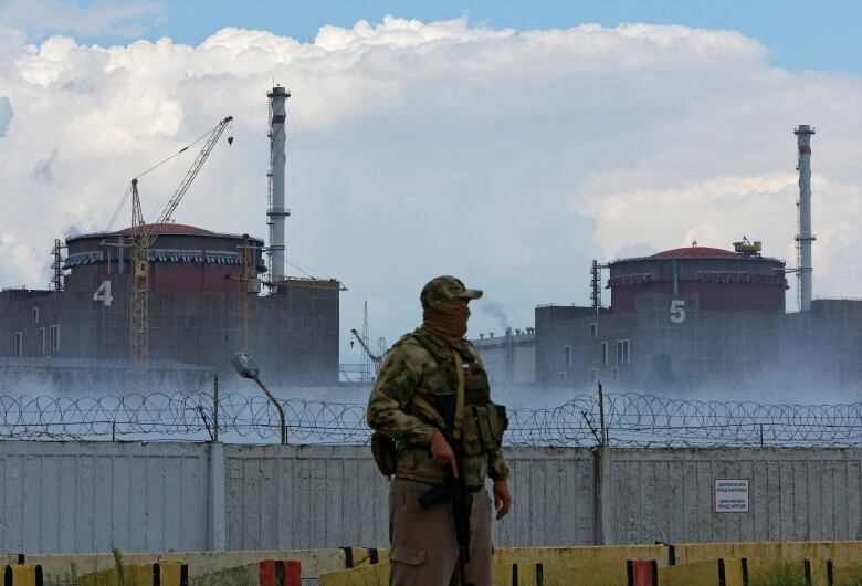 A serviceman with a Russian flag on his uniform stands guard near the Zaporizhzhia Nuclear Power Plant in the course of Ukraine-Russia conflict outside the Russian-controlled city of Enerhodar in the Zaporizhzhia region, Ukraine August 4, 2022.