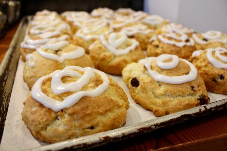 A tray of scones with icing.