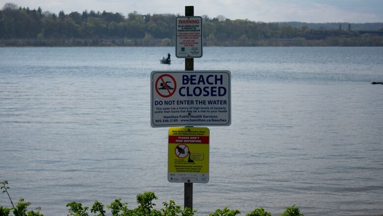 A sign that tells people not to swim in the water.