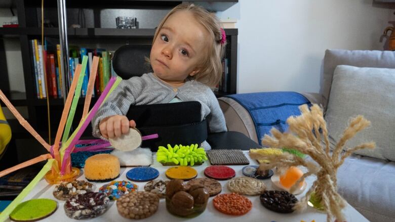 Amelia Griffith-Thomas, 22 months, plays with her busy board at home in Ottawa on Nov. 22, 2022, less than a week after she was discharged from CHEO. She was in hospital recovering from respiratory problems stemming from common cold viruses. 