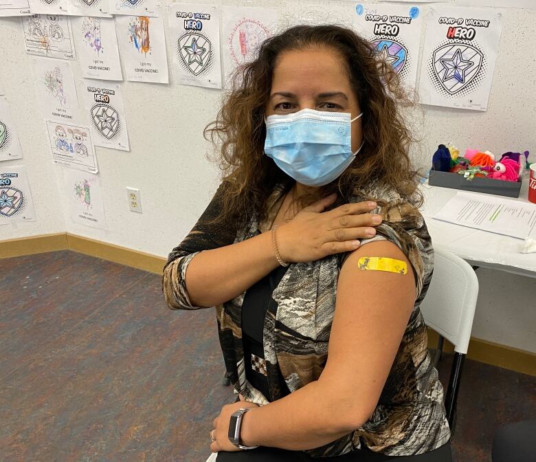 Woman shows bandage on arm after receiving annual flu vaccine.