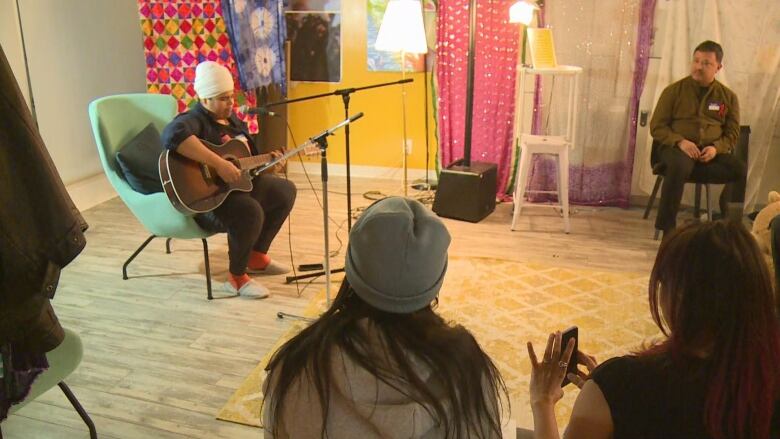 A person plays a guitar at an open mic night.