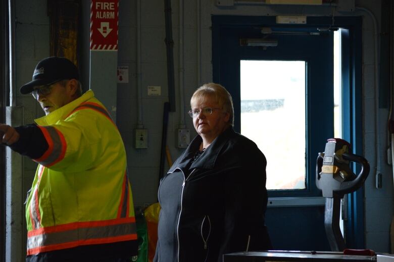 A woman watches a man in a high viz vest