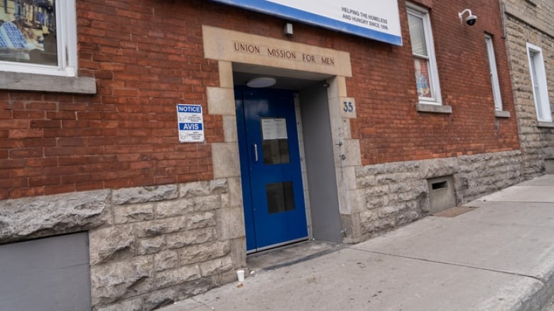 A building with a blue door facing a street. 