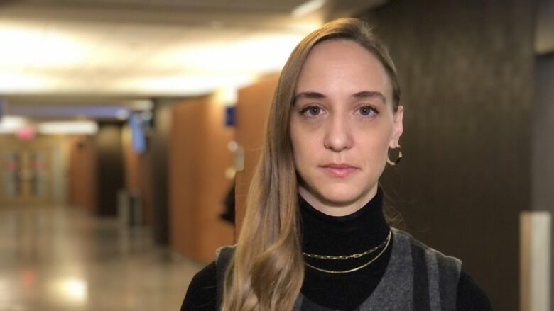 Head and shoulders portrait of young woman in courthouse hallway.