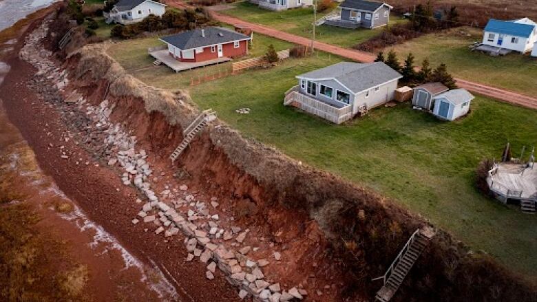 Aerial view of damage from Fiona in front of a row of cottages 