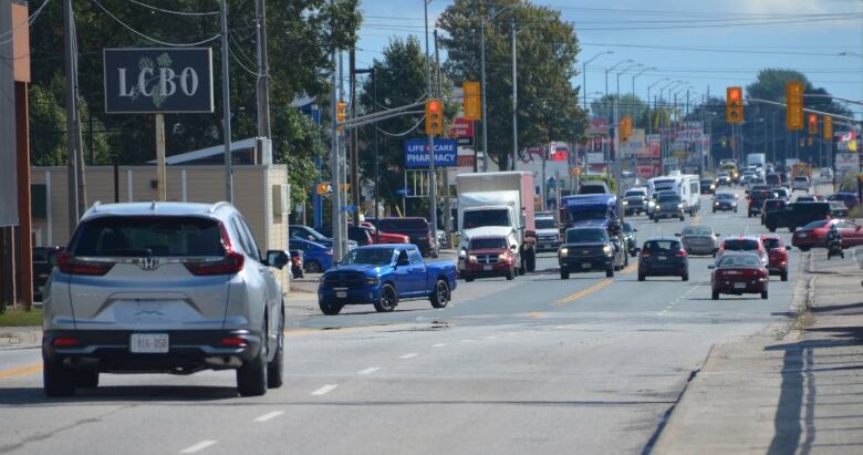 Lots of traffic on Highway 17 passing through Sturgeon Falls on a summer day, with lots of signs for businesses lining the roadway 