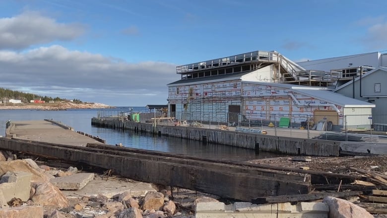 The Victoria Co-op Fisheries building in Neils Harbour. The building is being repaired, with staging erected and siding being replaced on the building. 