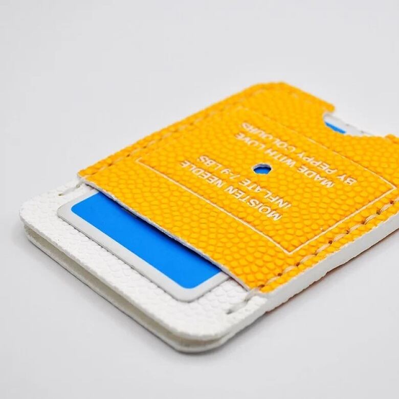 Photo of a cardholder made of yellow and white basketball leather.