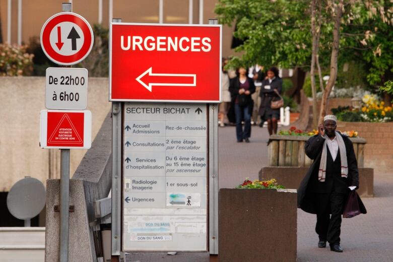 An exterior view of people walking by a hospital in France in 2009 during the H1N1 flu pandemic.