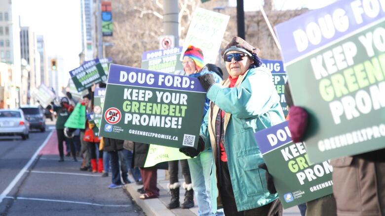 Protesters held both handmade and printed signs with pictures and messages to stop Bill 23.