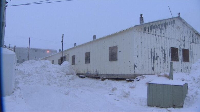 A white building with snow surrounding it.