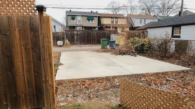 A partial fence is beside a slab of concrete. 