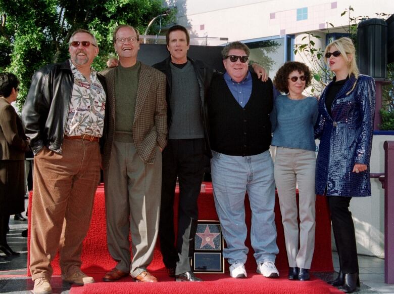 5 actors from the TV series Cheers standing on a red carpet.