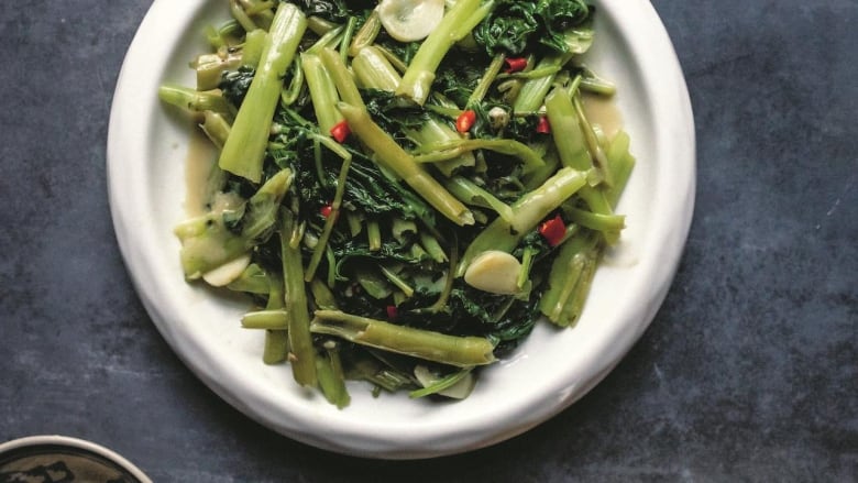 An overhead shot of a white plate of Stir-Fried Water Spinach with Fermented Tofu. 