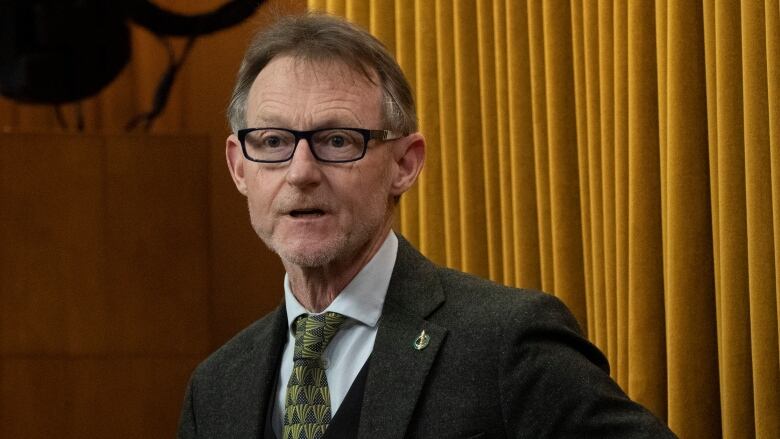 Man in glasses and a tie looking at the camera