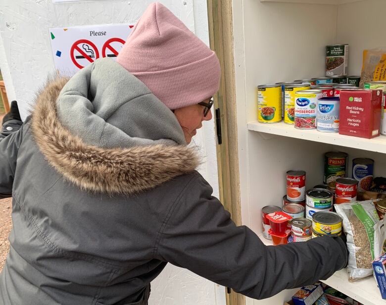 Woman puts food in a pantry 