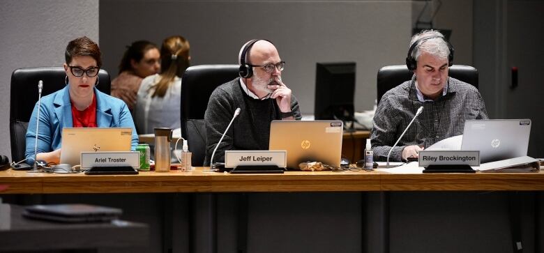 A group of city councillors listen at a meeting.