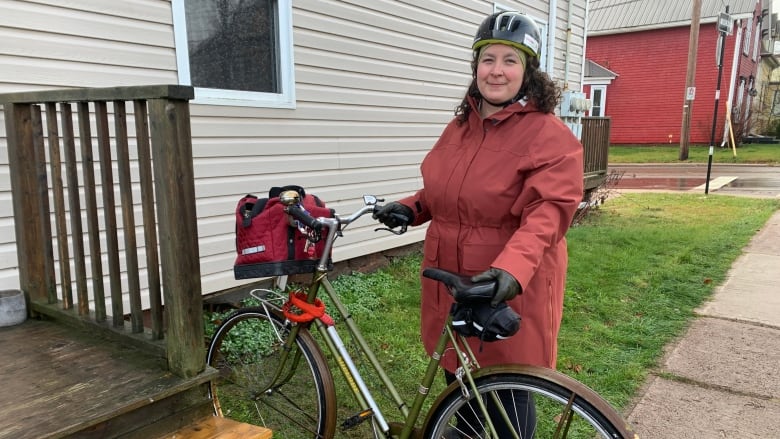 Woman holding a bicyle with a helmet on