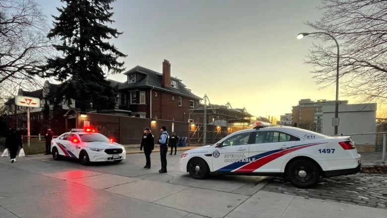 Two police cars block off the entrance to the TTC station.