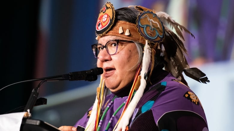 Archibald address delegates wearing her AFN headdress.