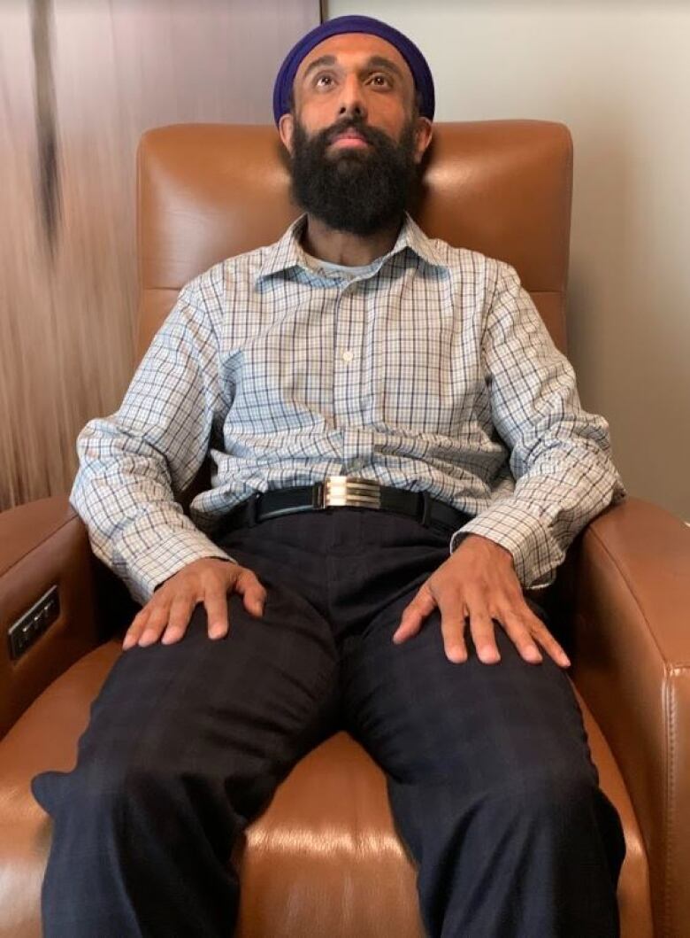 A man sits back in a leather chair.