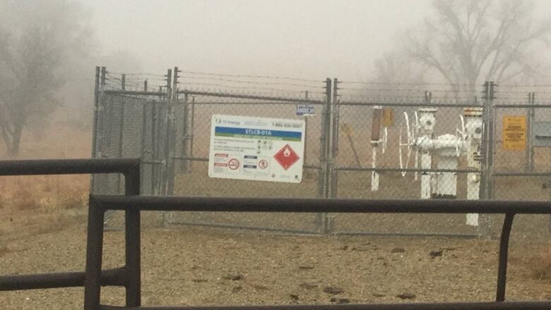 a view of a metal fence in front of a field. 