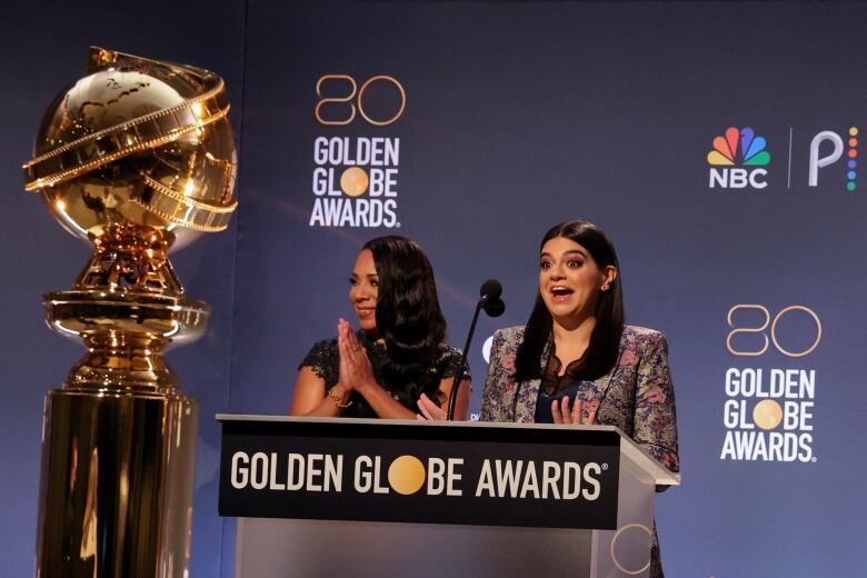 Two women stand at a podium.