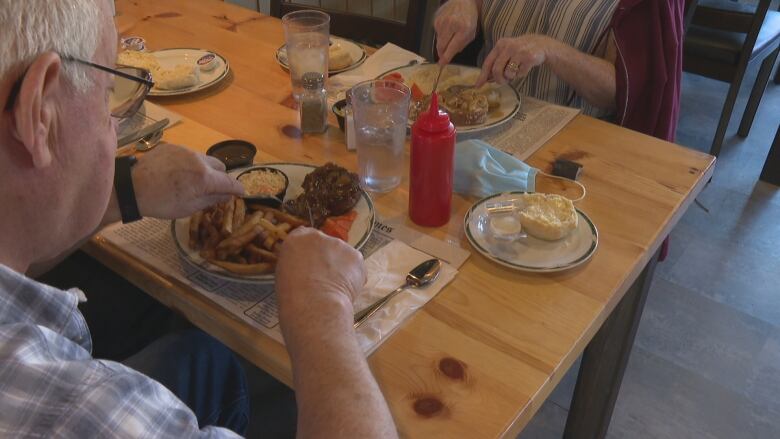 A couple eating a meal together at a table. 