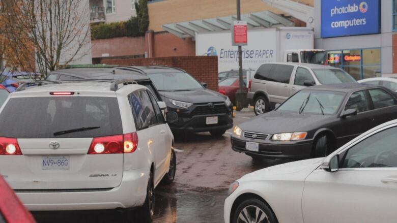 Cars struggle to park in a parking lot. 