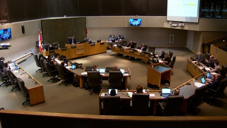 Sudbury council chamber seen from above. Councillors and staff sitting at desks with computers. 