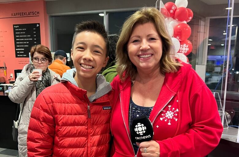 Two people pose for a photo in the CBC Calgary lobby.