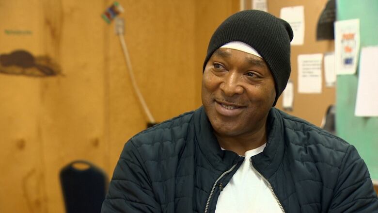 A man sitting in a classroom smiles