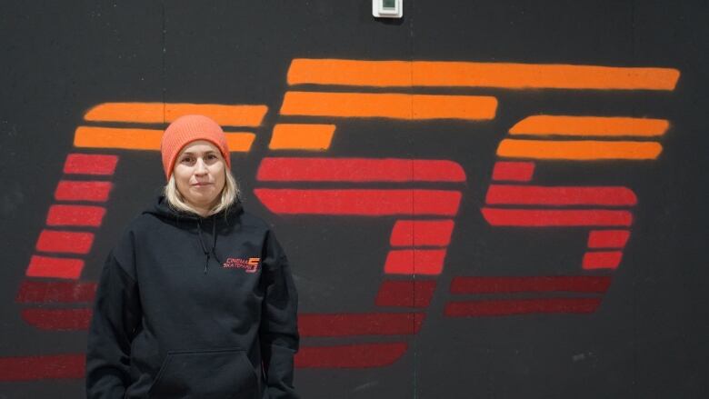 A woman standing in front of her new skatepark's logo