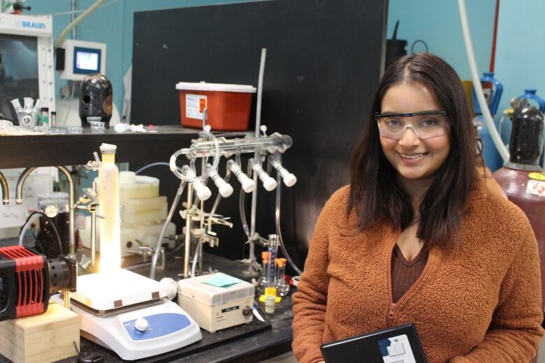 Sarrah Putwa, a graduate student in the Dasog lab, poses with an artificial photosynthesis setup the lab is using to produce green hydrogen.