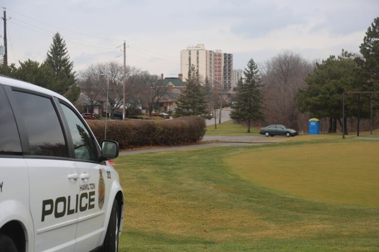 An apartment building beside a police car. 