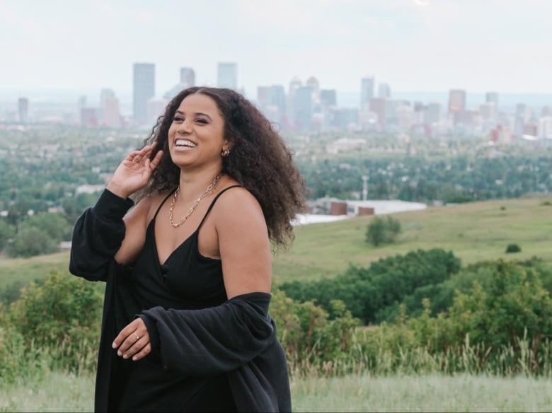 Smiling woman with Calgary city skyline behind her