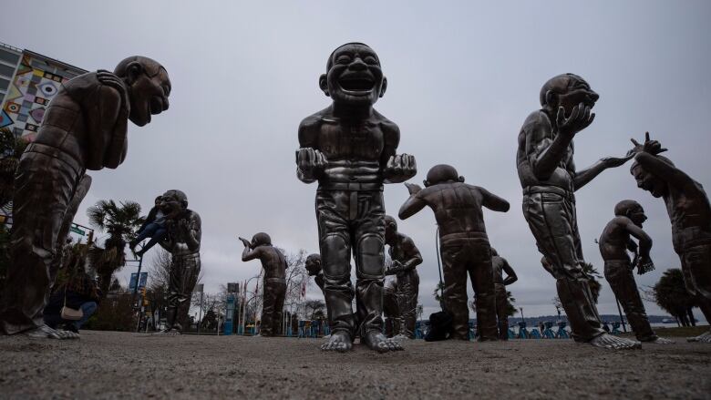 Bronze statues of 14 men appear in various poses in Vancouver B.C.'s West End neighbourhood.