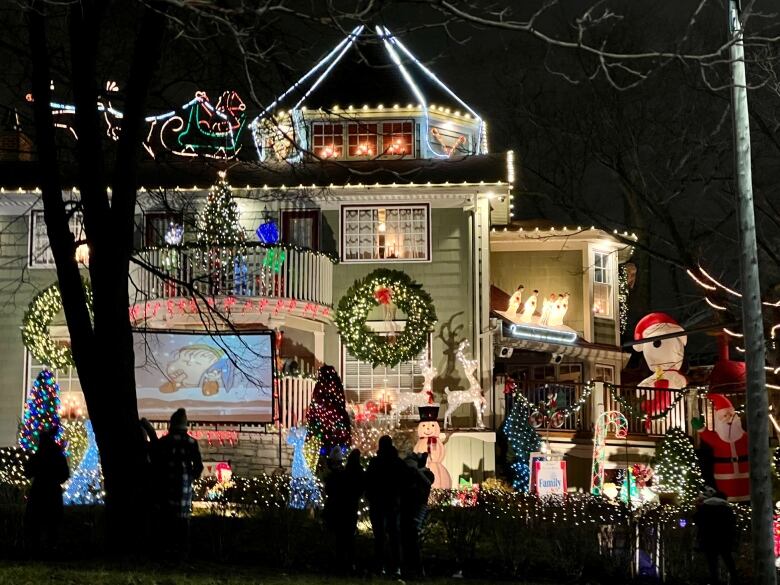 House illuminated by various Christmas Christmas displays including snowmen and a sled