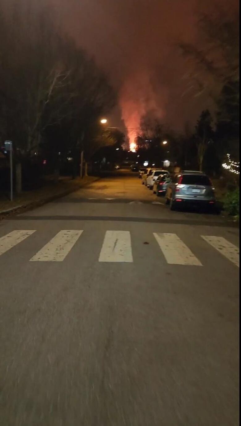 A first-person shot of a street, with red smoke clearly visible at the other end of the street.